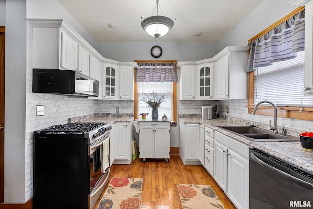 2016 12th St, Rock Island, IL 61201 - kitchen featuring stainless steel appliances, plenty of natural light, glass insert cabinets, and white cabinets