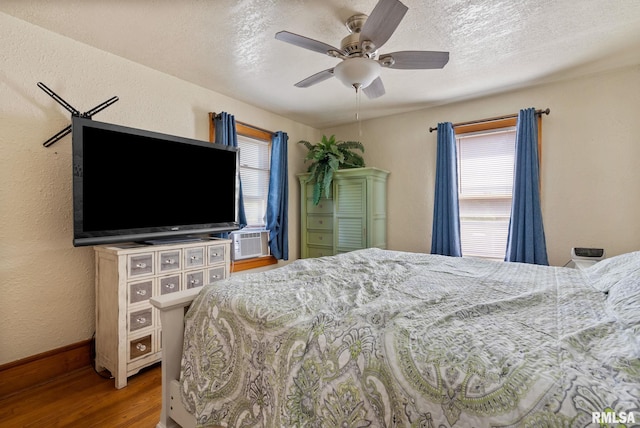 2016 12th St, Rock Island, IL 61201 - bedroom with wood finished floors, multiple windows, cooling unit, a textured ceiling, and a ceiling fan