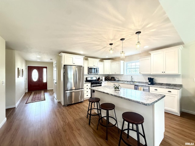 312 Mcvicker Dr, Energy, IL 62933 - kitchen featuring appliances with stainless steel finishes, a kitchen breakfast bar, white cabinets, a kitchen island, and recessed lighting