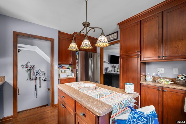 412 24th Ave, East Moline, IL 61244 - kitchen featuring freestanding refrigerator, wood finished floors, hanging light fixtures, a center island, and brown cabinetry