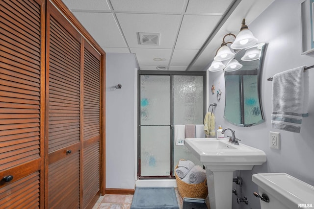 412 24th Ave, East Moline, IL 61244 - bathroom featuring a stall shower, a paneled ceiling, and a closet