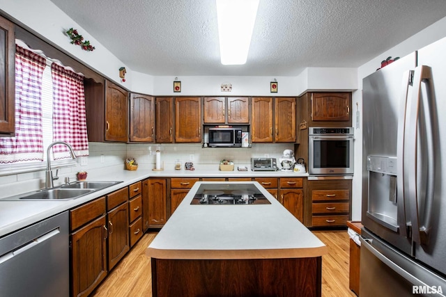 1903 Melvin Rd, West Frankfort, IL 62896 - kitchen featuring appliances with stainless steel finishes, a textured ceiling, light wood finished floors, light countertops, and a kitchen island