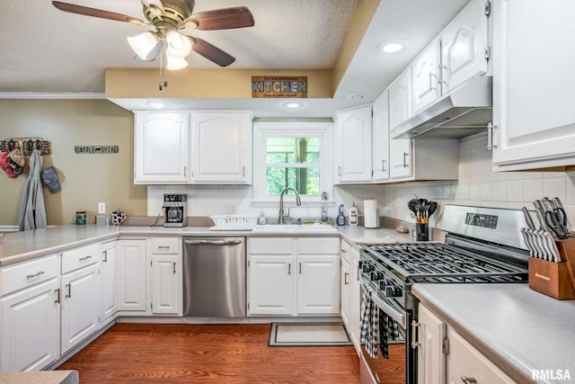 5680 State Route 146 E Highway, Vienna, IL 62995 - kitchen with appliances with stainless steel finishes, under cabinet range hood, a ceiling fan, wood finished floors, and white cabinets