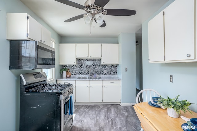 1817 W 3rd St, Milan, IL 61264 - kitchen with appliances with stainless steel finishes, ceiling fan, backsplash, white cabinetry, and light stone counters