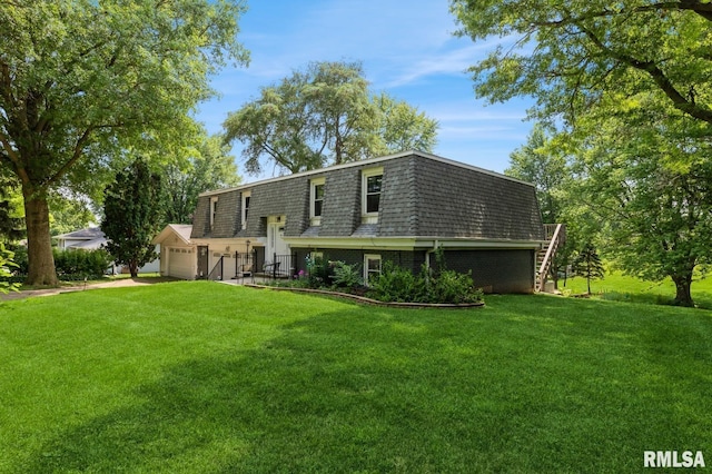 15611 Willow Ct, Sterling, IL 61081 - back of house featuring a yard, mansard roof, a garage, brick siding, and stairs
