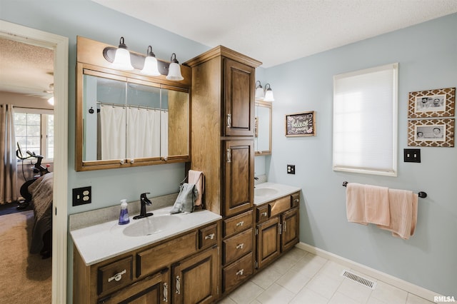 10224 Illinois Steel Rd, Johnston City, IL 62951 - bathroom with double vanity, connected bathroom, a textured ceiling, ceiling fan, and tile patterned floors