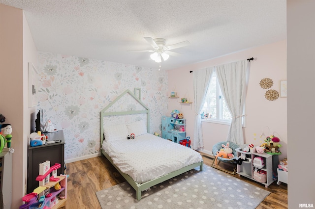 10224 Illinois Steel Rd, Johnston City, IL 62951 - bedroom featuring wallpapered walls, wood finished floors, a textured ceiling, and a ceiling fan