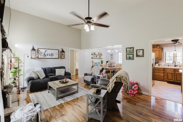 10224 Illinois Steel Rd, Johnston City, IL 62951 - living area featuring ceiling fan, high vaulted ceiling, light wood-type flooring, and a chandelier