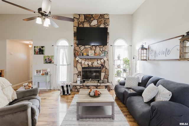 10224 Illinois Steel Rd, Johnston City, IL 62951 - living room with a high ceiling, a ceiling fan, wood finished floors, and a stone fireplace