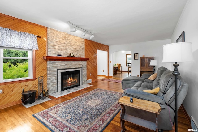 5003 48th St, Moline, IL 61265 - living area with track lighting, arched walkways, wooden walls, a fireplace, and wood finished floors