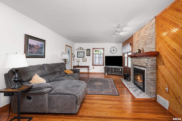 5003 48th St, Moline, IL 61265 - living room with wood walls, a stone fireplace, and wood finished floors