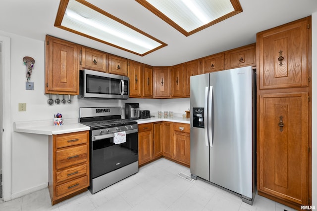 5003 48th St, Moline, IL 61265 - kitchen featuring stainless steel appliances, brown cabinetry, and light countertops