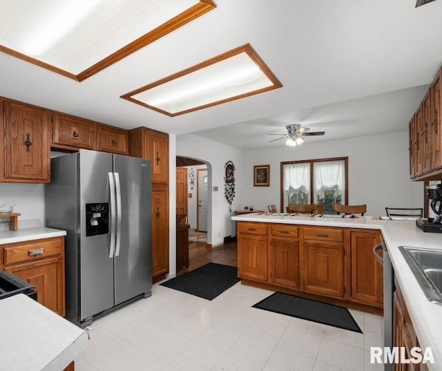 5003 48th St, Moline, IL 61265 - kitchen with stainless steel refrigerator with ice dispenser, arched walkways, brown cabinetry, and light countertops