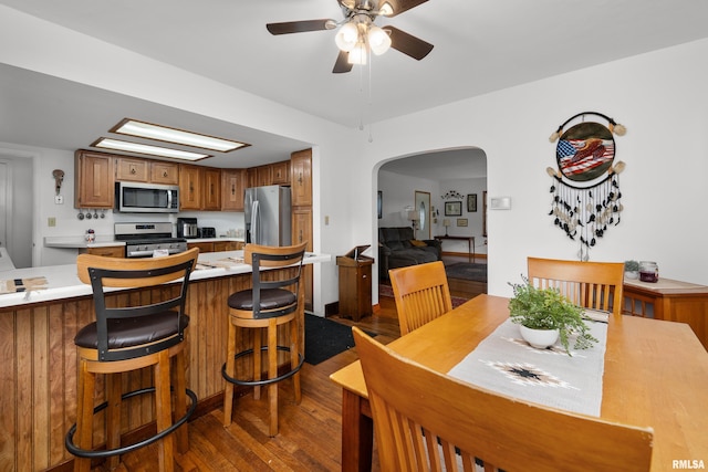 5003 48th St, Moline, IL 61265 - dining space with ceiling fan, arched walkways, and dark wood-style floors