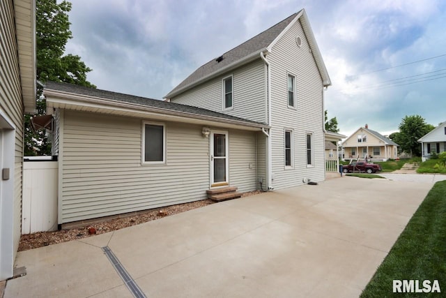 2024 Lind St, Quincy, IL 62301 - back of house with entry steps, concrete driveway, a patio, and a shingled roof