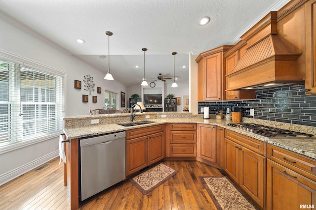 627 10th Ave, Silvis, IL 61282 - kitchen featuring appliances with stainless steel finishes, premium range hood, hardwood / wood-style floors, a peninsula, and tasteful backsplash