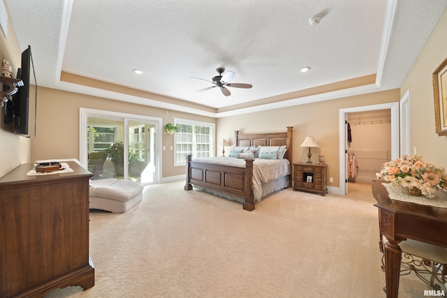 627 10th Ave, Silvis, IL 61282 - bedroom featuring a tray ceiling, access to exterior, light colored carpet, a textured ceiling, and a walk in closet