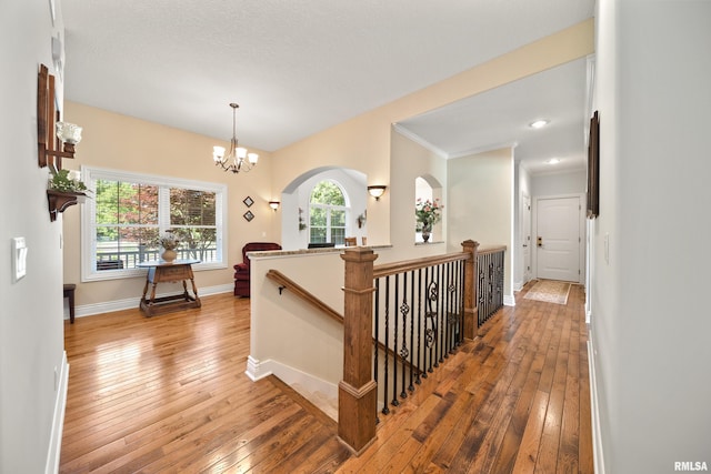 627 10th Ave, Silvis, IL 61282 - hall with hardwood / wood-style floors, an upstairs landing, a chandelier, and arched walkways