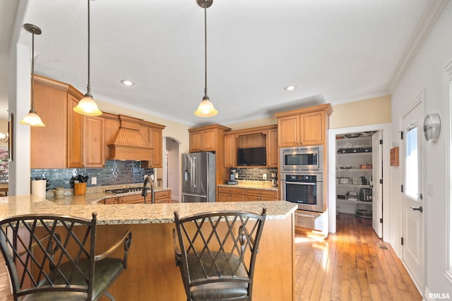 627 10th Ave, Silvis, IL 61282 - kitchen with appliances with stainless steel finishes, decorative backsplash, ornamental molding, a peninsula, and light wood-type flooring