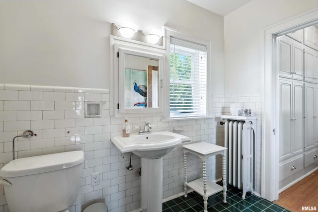 118 Ridgewood Ave, Davenport, IA 52803 - bathroom featuring radiator heating unit, tile walls, a wainscoted wall, and tile patterned floors