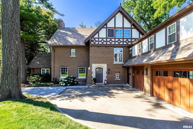 118 Ridgewood Ave, Davenport, IA 52803 - tudor house with an attached garage, a chimney, brick siding, and driveway