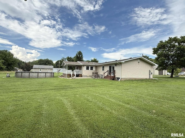 15293 Wall St, Carterville, IL 62918 - back of house with entry steps, an outdoor pool, and a lawn