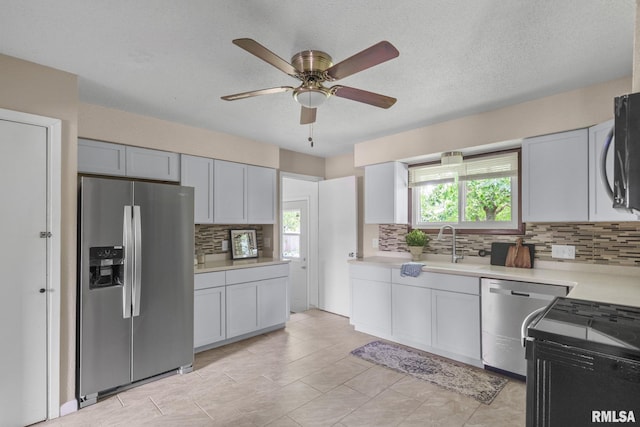5210 N Division St, Davenport, IA 52806 - kitchen with stainless steel appliances, tasteful backsplash, light countertops, ceiling fan, and healthy amount of natural light