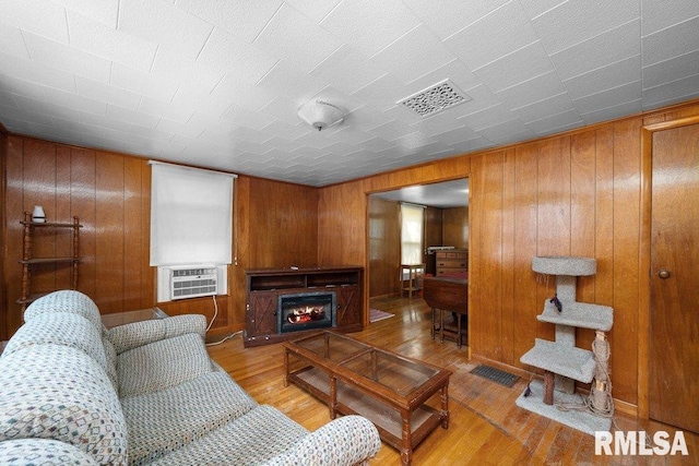 202 Washington Ave, Osco, IL 61274 - living area with wooden walls, hardwood / wood-style flooring, cooling unit, and a lit fireplace