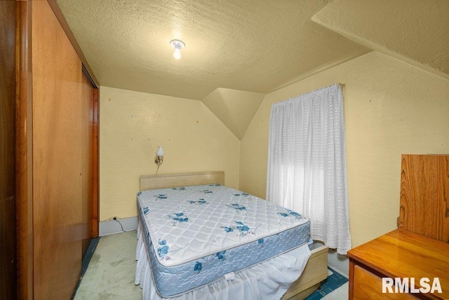 202 Washington Ave, Osco, IL 61274 - bedroom featuring a textured ceiling, light carpet, and vaulted ceiling