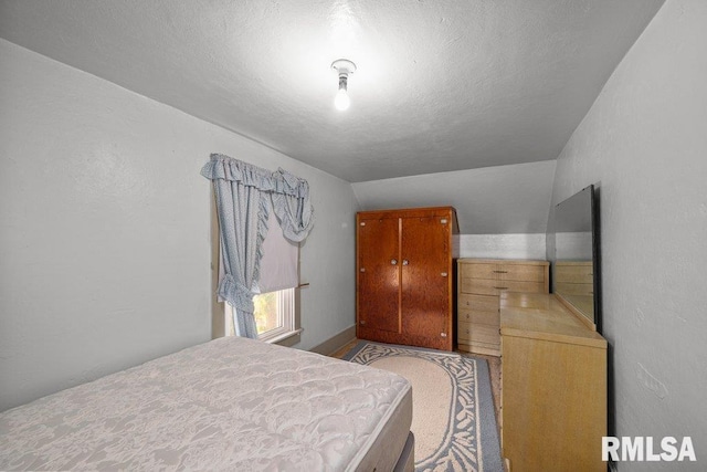 202 Washington Ave, Osco, IL 61274 - bedroom with lofted ceiling and a textured ceiling