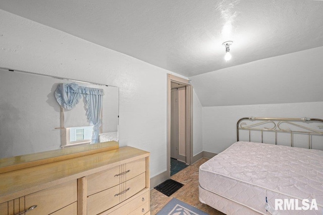 202 Washington Ave, Osco, IL 61274 - bedroom featuring vaulted ceiling, a textured ceiling, and wood finished floors