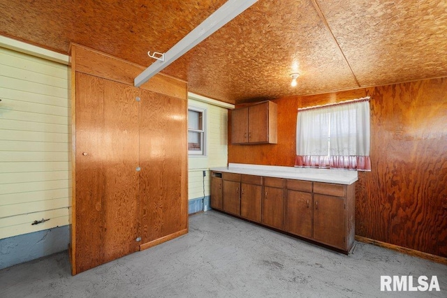 202 Washington Ave, Osco, IL 61274 - kitchen with wood walls, brown cabinets, light countertops, and concrete floors