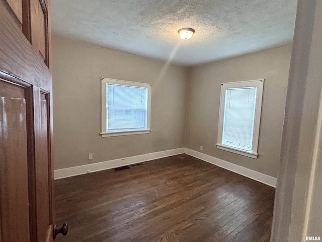 170 16th Ave, East Moline, IL 61244 - unfurnished room with plenty of natural light, dark wood-style flooring, and a textured ceiling