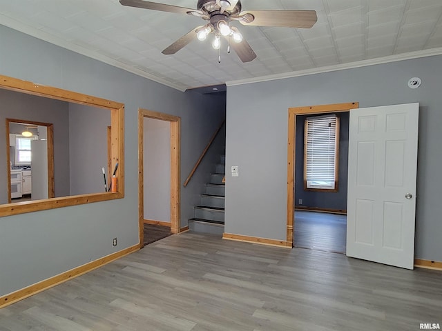 819 12th Ave S, Clinton, IA 52732 - spare room with ornamental molding, stairway, a ceiling fan, and wood finished floors