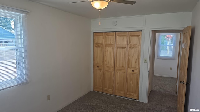 1102 40th St, Moline, IL 61265 - unfurnished bedroom featuring dark carpet, multiple windows, a closet, and ceiling fan