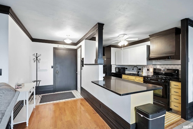 1800 7th St Unit 10E, East Moline, IL 61244 - kitchen featuring black gas stove, dark countertops, ornamental molding, premium range hood, and tasteful backsplash