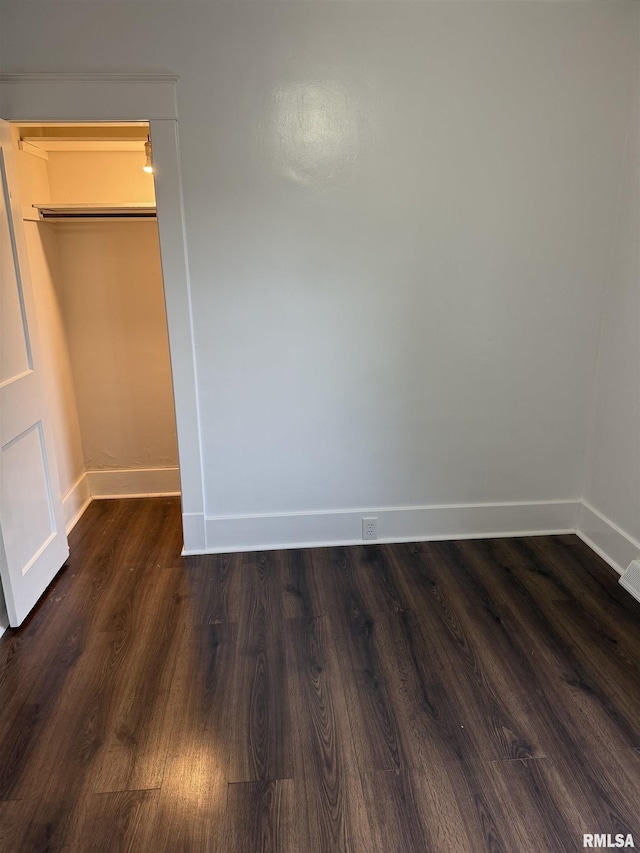235 20th Pl, Clinton, IA 52732 - unfurnished bedroom with baseboards and dark wood-style floors