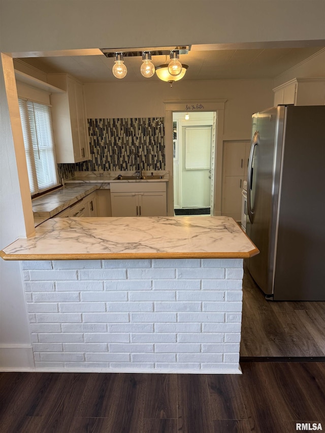 235 20th Pl, Clinton, IA 52732 - kitchen with stainless steel refrigerator with ice dispenser, white cabinetry, a peninsula, dark wood-style floors, and backsplash