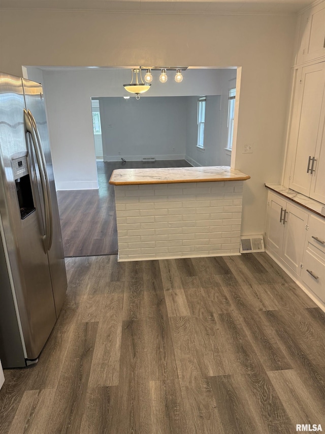 235 20th Pl, Clinton, IA 52732 - kitchen with stainless steel fridge, dark wood finished floors, white cabinets, and healthy amount of natural light