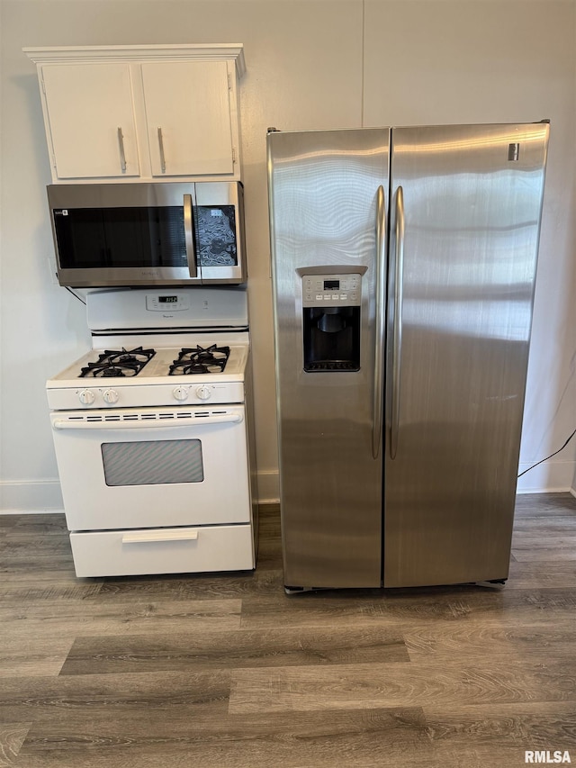 235 20th Pl, Clinton, IA 52732 - kitchen with stainless steel appliances, dark wood-style floors, and white cabinets