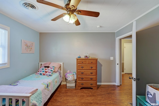 1217 7th St, De Witt, IA 52742 - bedroom featuring wood finished floors, crown molding, and ceiling fan