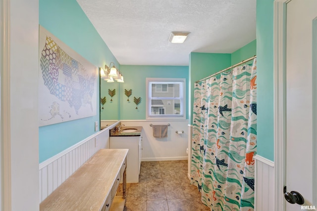 1217 7th St, De Witt, IA 52742 - full bath featuring a textured ceiling, vanity, wainscoting, tile patterned floors, and a shower with shower curtain