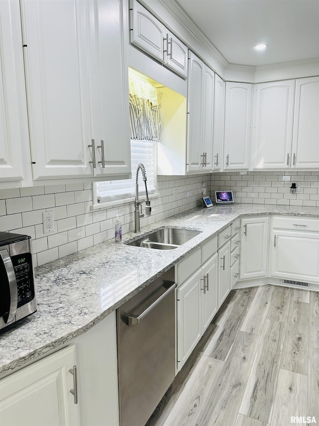616 Elk St, Sabula, IA 52070 - kitchen featuring stainless steel appliances, light wood-style flooring, white cabinets, and tasteful backsplash