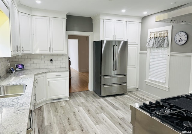 616 Elk St, Sabula, IA 52070 - kitchen featuring high end refrigerator, light wood-type flooring, light stone counters, tasteful backsplash, and white cabinetry