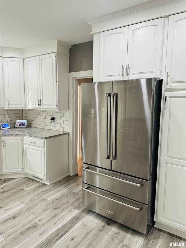 616 Elk St, Sabula, IA 52070 - kitchen featuring high quality fridge, white cabinets, backsplash, and light wood-type flooring
