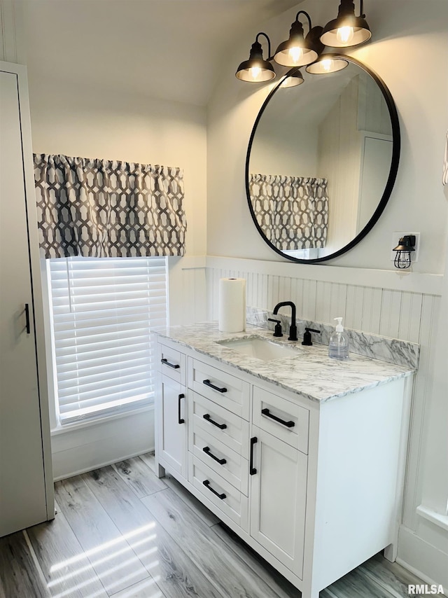 616 Elk St, Sabula, IA 52070 - bathroom featuring vanity, a wainscoted wall, wood finished floors, and a chandelier