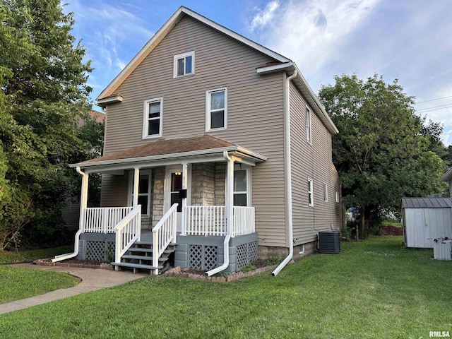 616 1st Ave, Silvis, IL 61282 - view of front facade with covered porch, a storage unit, a front lawn, and stone siding
