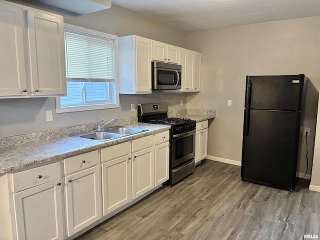 616 1st Ave, Silvis, IL 61282 - kitchen featuring appliances with stainless steel finishes, light wood-type flooring, white cabinets, and light countertops