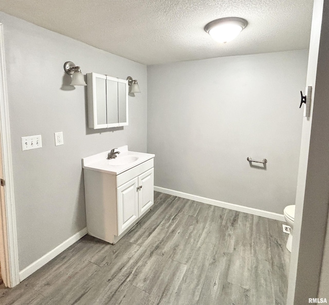 616 1st Ave, Silvis, IL 61282 - bathroom featuring vanity, wood finished floors, and a textured ceiling