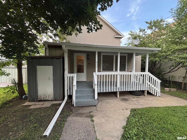 616 1st Ave, Silvis, IL 61282 - view of front facade featuring covered porch and a shed